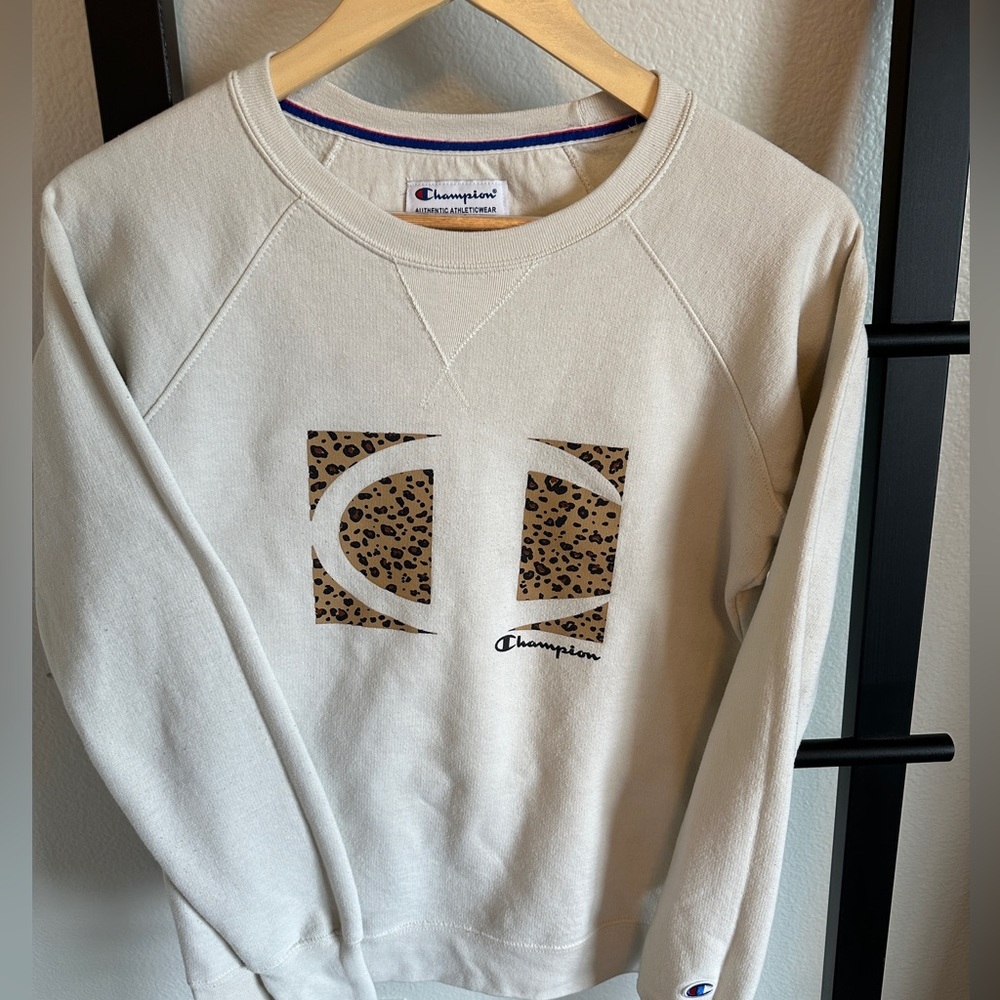 Cream Champion brand crew sweatshirt with leopard print brand detail.